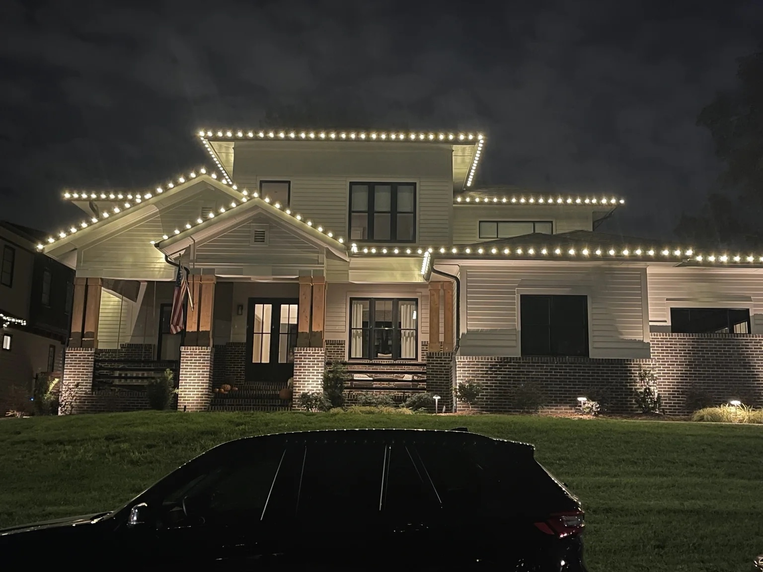 Warm white C9 Christmas roofline lighting installed on a Charlotte, NC home by Little Elves Lighting Pros