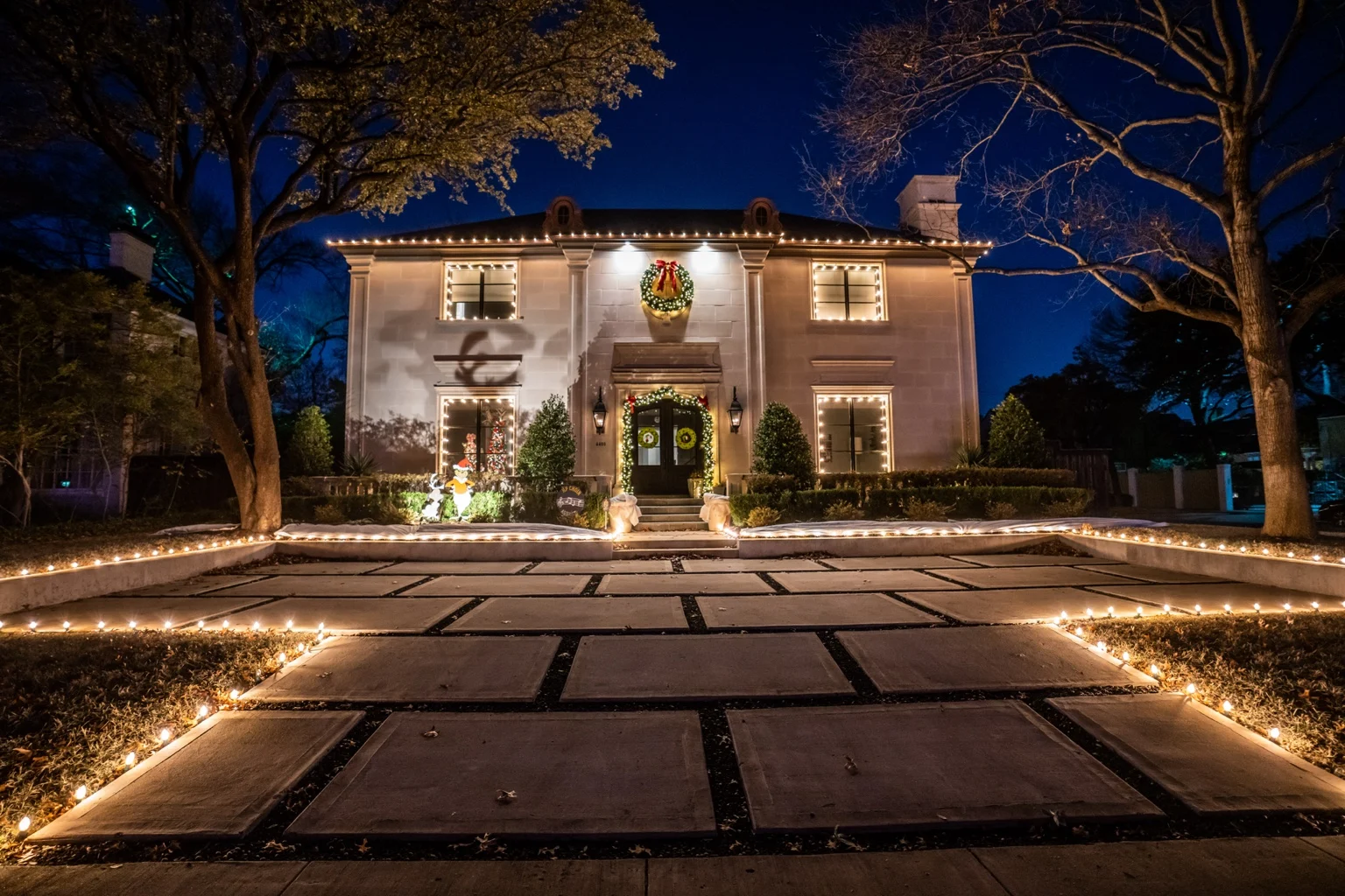 Little Elves installation with warm white rooflines, glowing windows and a lit front walkway
